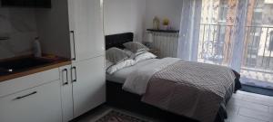 a small bedroom with a bed and a window at Apartament 59 JUSTI in Zator