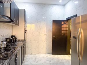 a kitchen with a refrigerator and a counter top at Oak Atlantic Layout - OTITO Suites in Lekki +41 photos