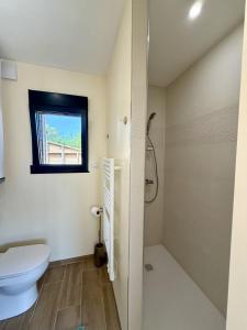 a bathroom with a toilet and a window at Le Cocon de May entre Terre et Mer a proximité de caen in May-sur-Orne +6 photos