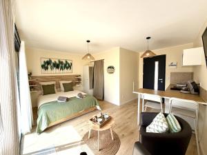 a bedroom with a bed and a desk in a room at Le Cocon de May entre Terre et Mer a proximité de caen in May-sur-Orne
