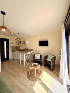 a living room with a couch and a table at Le Cocon de May entre Terre et Mer a proximité de caen in May-sur-Orne