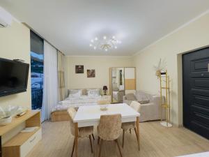 a living room with a bed and a white table at Rusa in P'eria