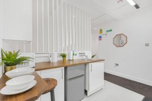 a kitchen with white appliances and a wooden table at Cosy Rooms in London +9 photos