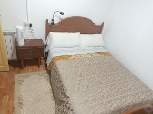 a bedroom with a bed and a night stand with a lamp at casa SARMA in Las Médulas