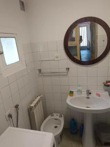 a bathroom with a sink and a toilet and a mirror at casa SARMA in Las Médulas