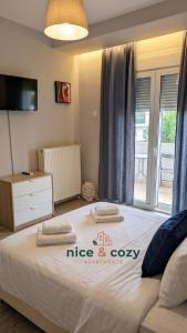 a bedroom with a large bed with a tv on it at Nice and Cozy Apartments in Néa Khilí