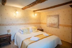 a bedroom with a large white bed in a room at Le refuge à la campagne in Toulonjac