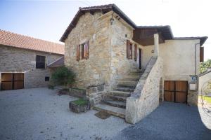 a stone house with a staircase in front of it at Le refuge à la campagne in Toulonjac