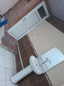 a toilet in a bathroom with a brick wall at myGrandma's home in Sheki +11 photos