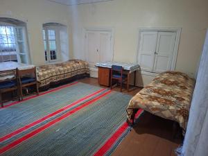a living room with two beds and a rug at myGrandma's home in Sheki