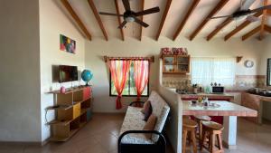 a living room with a ceiling fan and a table at The Inner Light Yoga Lodge in Sámara +42 photos