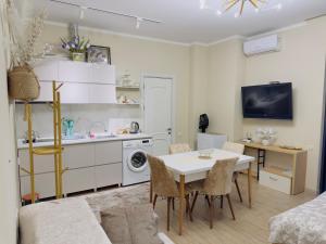 a kitchen and a living room with a table and chairs at Rusa in P'eria +3 photos