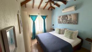 a bedroom with a bed with blue walls and a ceiling at The Inner Light Yoga Lodge in Sámara