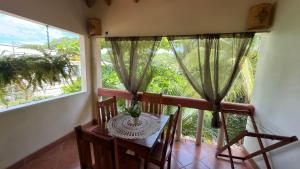 a balcony with a table and two chairs and a window at The Inner Light Yoga Lodge in Sámara