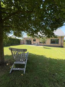 a bench sitting under a tree in a yard at De 50 Steenbrugge in Oostkamp