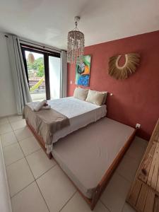 a bedroom with a bed and a red wall at Casa Macao Pipa in Pipa