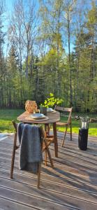 a wooden table and chairs on a wooden deck at Odskocznia bliżej lasu in Korczyna