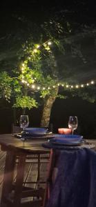 a table with two wine glasses and a tree with lights at Odskocznia bliżej lasu in Korczyna +18 photos