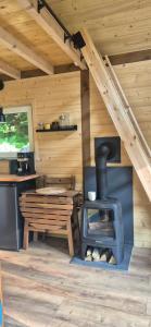 a room with a stove and a table in a cabin at Odskocznia bliżej lasu in Korczyna