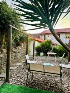 a patio with benches and a table and palm trees at Oi Braga Hostel in Braga