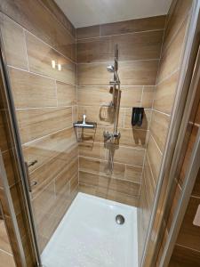 a bathroom with a shower with wooden walls at Le chalet chartreux in Sarcenas +25 photos