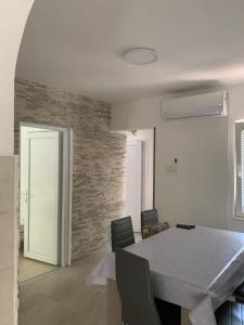 a dining room with a white table and chairs at Čanj apartmani in Čanj