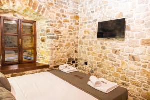 a stone walled room with a bed with towels on it at Vila Blin in Berat