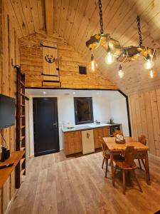 a dining room with a table and a kitchen at Le chalet chartreux in Sarcenas