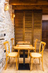 a wooden table and chairs in a room at Vila Blin in Berat