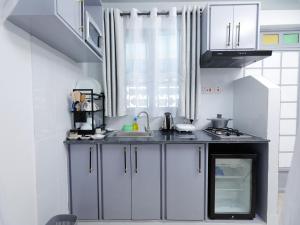 a kitchen with white cabinets and a sink at Self Contained Studio in Nakuru