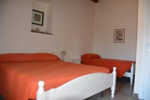 a bedroom with a bed with an orange blanket at Agriturismo Arona in Sperlinga