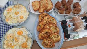 a table topped with plates of food with eggs and bread at Irene's rooms in Himare