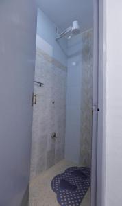 a bathroom with a shower with a rug on the floor at Self Contained Studio in Nakuru +11 photos