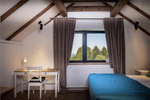 a bedroom with a bed and a desk and a window at Holiday Residence Banfi in Štrigova +30 photos