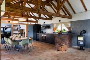 a kitchen with a table and chairs and a fireplace at Holiday Residence Banfi in Štrigova