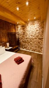 a bedroom with a bed and a stone wall at Casa Stratigos in Corfu
