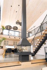 a fireplace in the middle of a room with stairs at Pur Nature et Spa Eastman in Eastman
