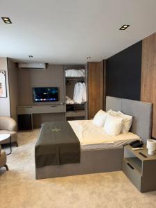 a bedroom with a bed and a tv in it at Fron Hotel in Prishtinë +53 photos
