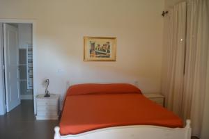 a bedroom with a bed with an orange blanket at Agriturismo Arona in Sperlinga +3 photos