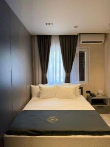 a bedroom with a large bed with a window at Fron Hotel in Prishtinë