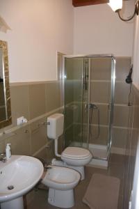 a bathroom with two toilets and a shower and a sink at Agriturismo Arona in Sperlinga