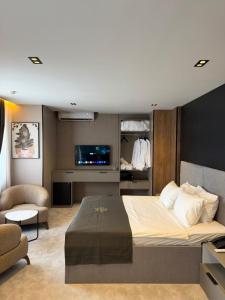 a bedroom with a large bed and a tv at Fron Hotel in Prishtinë