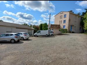 a parking lot with cars parked in front of a building at La plage - Mauzac in Limoux