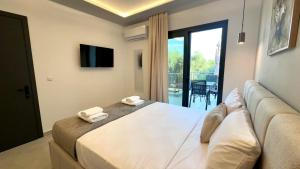 a bedroom with a large bed with two towels at Mimoza Apartments in Limenaria