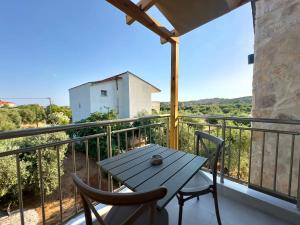 a table and chairs on a balcony with a view at Mimoza Apartments in Limenaria