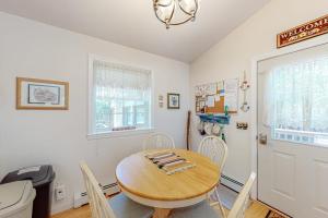 a dining room with a wooden table and chairs at Inviting dog-friendly home with firepit & Ping-Pong - near Acadia National Park in Ellsworth +18 photos