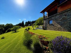 a house with a grassy yard next to a building at Apartment Boris Sveta Planina in Knezdol