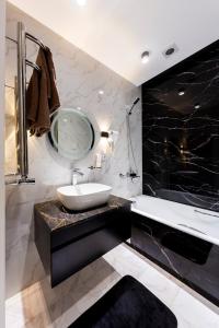 a black and white bathroom with a sink and a mirror at Gardence Residence Suite in Tashkent
