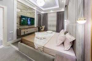 a bedroom with a large bed and a tv at Gardence Residence Suite in Tashkent