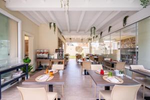 un ristorante con tavoli e sedie in una stanza di Suimi's Hotel a Villasimius
